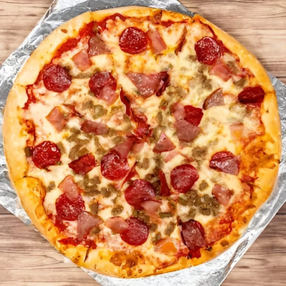Bravo Pizza's meat lover's pizza, topped with pepperoni, sausage, and ham, on a wooden table.