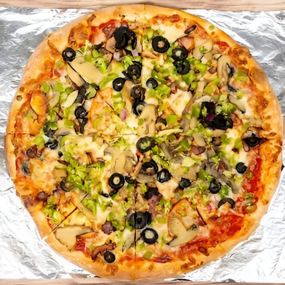 Bravo Pizza's whole pizza with olives, green peppers, and mushrooms on aluminum foil.